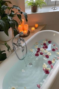 a bathtub filled with flowers and candles next to a window