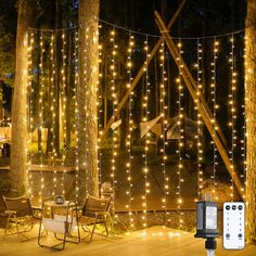 an outdoor deck with lights strung around the trees and stringing on the fence to make it look like something out of a fairy tale