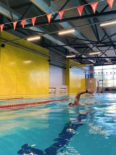 an indoor swimming pool with people in it