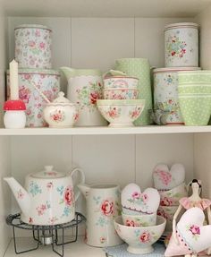 the shelves are filled with dishes and cups