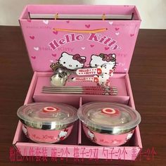 two hello kitty dishes in a pink box with spoons and utensils inside