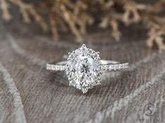 a diamond ring on top of a piece of fabric with some branches in the background