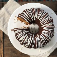 a chocolate bundt cake with white icing on a plate