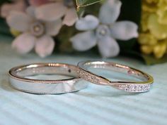 two wedding rings sitting on top of a table