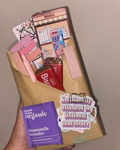 a person holding a brown bag filled with lots of items and stickers on it