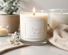 a white candle sitting on top of a table next to other candles and napkins