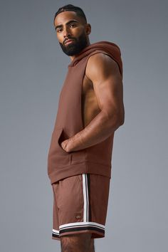 Stay cozy without sacrificing style in the Renown Sleeveless Hoodie. It has deep armholes, a kangaroo pocket, and a laid-back cut. And wait till you feel the Alo signature Renown fabric—it's smooth on the outside, a little fleecy on the side, and heavyweight for a just-right drape. Add shorts and you’re covered from the gym to the street. Athleisure Tops With Kangaroo Pocket For Streetwear, Brown Sleeveless Activewear For Sports, Sleeveless Cotton Hoodie For Loungewear, Athleisure Hoodie Top With Pockets, Sporty Brown Hoodie With Pockets, Casual Brown Stretch Vest, Alo Yoga Hooded Top With Drawstring Hood, Brown Sleeveless Activewear For Workout, Brown Sleeveless Athleisure Activewear