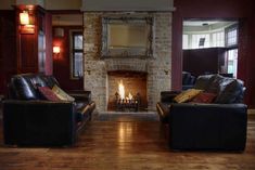 a living room with two couches and a fire place in the fireplace between them