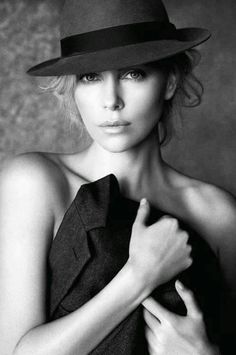 black and white photograph of a woman wearing a hat with her hands on her chest