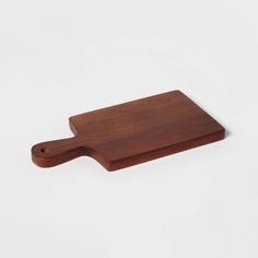 a wooden cutting board sitting on top of a white table