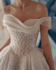 a woman in a white wedding dress is standing with her hands on her hips and looking off to the side