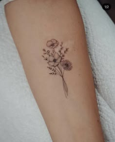 a woman's arm with a flower tattoo on the left side of her arm