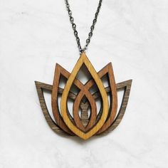 a wooden necklace with an intricate design on it's chain, hanging from a marble wall