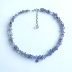 Enhance your everyday or festive look with this elegant handmade beaded necklace. Each necklace is crafted with meticulous attention to detail, adding a unique cultural charm to your style. This piece is perfect for your wardrobe or as a delightful gift for lovers of unique accessorie. This handmade necklace features genuine amethyst chips paired with shimmering purple beads. It includes an adjustable clasp for a perfect fit and offers customization options to suit your preferences. Made with st Adjustable Faceted Bead Choker Necklaces, Adjustable Faceted Bead Choker Necklace, Adjustable Gemstone Beaded Dangle Necklaces, Festival Crystal Necklaces With Round Gemstone Beads, Gemstone Beaded Necklaces With Round Mineral Crystal Beads, Adjustable Gemstone Beaded Necklace With Mineral Crystal, Adjustable Faceted Beads Crystal Necklace For Festival, Purple Gemstone Beads Necklace For Festivals, Adjustable Amethyst Beads For Jewelry Making