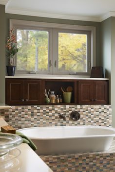 a bathroom with a tub, sink and window in the corner on the far wall