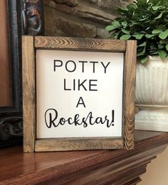 a wooden sign that says potty like a rockstar on top of a mantle