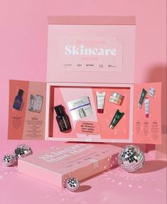 an assortment of skin care products in a pink box on a pink surface with disco balls