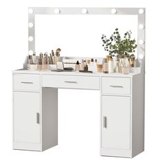 a white vanity with lights on it and a plant in front of the makeup mirror