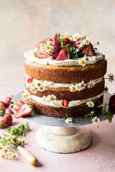 a cake with strawberries and daisies on top