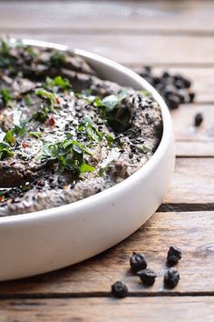 a white bowl filled with food on top of a wooden table