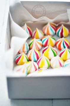 a box filled with lots of colorfully colored candies on top of a table