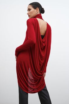 Halle will get you noticed for all the right reasons. Beautiful draping gives her a dramatic look, with flowing folds of sheer European jersey creating a sophisticated cowl back. The relaxed fit, turtleneck, and long sleeves with edgy thumbhole detailing all perfectly frame the draped back, giving a glimpse of skin for the feel of glamour.[SPLIT] Astrid, in red, is 5'9" (175 cm) tall, wearing size XS. Sam, in black, is 5'8" (173 cm) tall, wearing size XS. Natalee, in light beige, is 5'10" (178 c Draped Tops, Relaxed Glamour, Turtleneck Tunic, High Low Tunic, Custom Dress, Sweatshirt Fabric, Dramatic Look, Long Sleeve Turtleneck, Long Sleeve Tunic