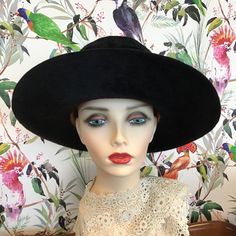 A fabulous vintage 1969 designer hat 'Meteor 15' by artisan hat makers Herbert Johnson of Bond Street London. Made from a black silk plush fabric, it features a wide brim and a high crease. The black band is rib corded and has a flat bow on the left side. The lining is ivory satin and is gathered at the crown. The crown is protected with a clear plastic cover, under which the maker's name is printed in gold and black, and there is also the royal coat of arms, by Appointment to Her Majesty The Qu Black High Crown Hat For Royal Ascot, Black High Crown Hat For Evening, Black Curved Brim Costume Hat For Church, Black Costume Hat With Curved Brim For Church, Black Costume Hat For Church With Curved Brim, Black Costume Hats For Church, Vintage Black Fedora Felt Hat, Black Mini Hat For Vintage Events And Kentucky Derby, Black Wide Brim Costume Hat For Evening