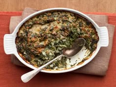 a casserole dish with spinach and cheese in it on a red place mat