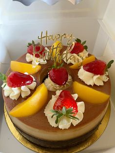 a birthday cake with strawberries, lemons and whipped cream on top is in a box