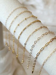 Please review the bracelet sizing guide below for the perfect fit! These dainty 14k Gold Filled Chain bracelets make a lovely addition to any bracelet stack! Simple and classic, these layering bracelets are made to compliment any outfit and are made with with sensitive skin safe, water safe, and long lasting materials! Details: * 14K Gold Filled chain and accents (USA 14/20 genuine Gold Filled) * Choose your chain style: Flat Cable Chain - 1.7x2mm Sequin Chain - 2.5x5mm  Beaded Satellite Chain - 2mm ball Figaro Chain - 2mm Paperclip Chain 1 - 3x6mm Paperclip Chain 2 - 2x5mm Heart Chain - 3.3mm (12K Gold Filled) Long Short Chain - 2mm * Choose your length (every bracelet has a .5" extender chain for adjustable sizing.) Bracelet Sizing Guide: 5-6.5 inches = xtra small 6.5-7 inches = small 7- Adjustable Delicate Chain Charm Bracelet, Dainty Adjustable Hypoallergenic Gold Bracelet, Dainty Adjustable Charm Bracelet With Extender, Dainty Charm Bracelet With Extender, Adjustable Gold Dainty Heart Bracelet, Dainty Adjustable Tarnish Resistant Chain Bracelet, Gold Minimalist Adjustable Heart Bracelet, Dainty Adjustable Paperclip Bracelet, Dainty Adjustable Chain Bracelet