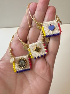 two small beaded purses in the palm of someone's hand