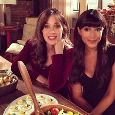 two women sitting at a table with plates of food