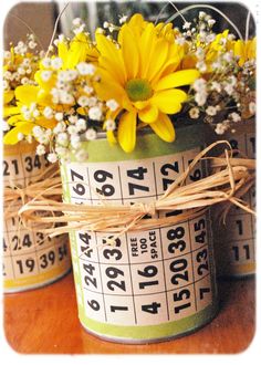 two yellow flowers are in a green bucket with numbers on it and tied to the side