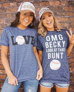 two women wearing matching shirts and baseball caps