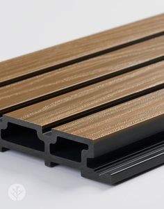 a close up view of some wood and black plastic slats on a white surface