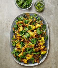 a plate full of food next to two bowls filled with greens