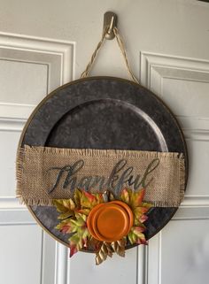 a metal plate hanging from a door with fall decorations on it