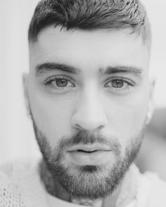 black and white photograph of a man wearing a sweater looking at the camera with an intense look on his face