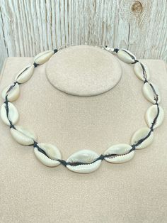 Cowrie Shell Choker Necklace. African natural white cowrie shells with Black hemp cord, silver plated cord ends, lobster clasp and 2" extender chain. Length Approx. 39.5cm (15.5") with a 2" entender chain Presented in a gift bag. A871 DELIVERY This item will be sent Free delivery UK ONLY via Royal Mail 1st class Standard. Estimated Delivery Next Day after item has been dispatched.                                                For Royal Mail International Standard Europe cost is £4.00 and USA is Black Jewelry With Adjustable Chain For Beach, White Jewelry With Adjustable Cord For Vacation, Silver Shell Necklace For Vacation, White Shell Necklace With Adjustable Cord As Gift, Adjustable White Cowrie Shell Choker, White Shell Necklace With Adjustable Chain For Beach, Adjustable Silver Shell Necklace For Beach, Handmade Adjustable Silver Shell, Beach-ready Adjustable Silver Jewelry