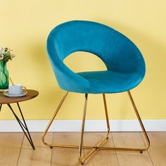 a blue chair sitting on top of a wooden table next to a vase with flowers