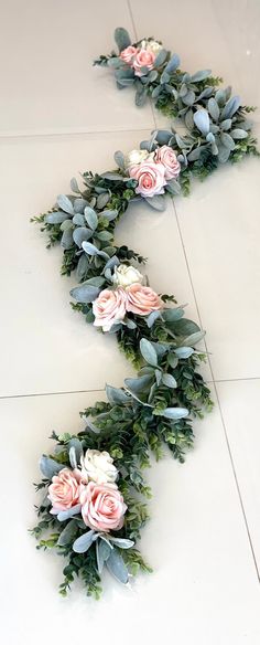 flowers and greenery are laid out on the floor to be used as garlands