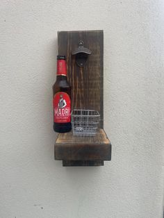 a bottle of beer sitting on top of a wooden shelf next to a metal basket