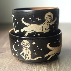 two black and gold cat wristbands sitting on top of each other