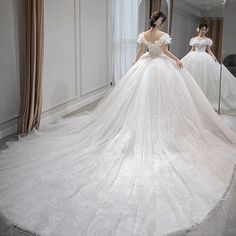 a woman in a wedding dress looking at herself in the mirror