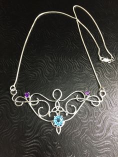 I love Victorian and Renaissance style statement necklaces with a magical and timeless flair, and I hope I've captured it within this piece! I shall fabricate for you this gorgeous Elvish/Renaissance style necklace, in sterling silver, with a center 8mm Blue Topaz and two side 4mm Amethyst gemstones. The center gemstone is 8mm round and the two sides are 4mm round. The chain will be soldered to each side and I will use a 1.2mm thick sterling box chain with a lobster claw clasp for added straight Bohemian Necklace With Sterling Silver Clasp, Silver Bohemian Birthstone Necklace, Bohemian Necklace With Sterling Silver Clasp For Gift, Artisan Necklace With Sterling Silver Clasp, Artisan Necklace With Sterling Silver Clasp For Gift, Bohemian Jewelry With Sterling Silver Clasp As Gift, Bohemian Jewelry Gift With Sterling Silver Clasp, Unique Sterling Silver Necklace Gift For Her, Spiritual Necklace With Sterling Silver Clasp As Gift