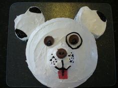 a cake shaped like a bear's head with googly eyes and nose rings