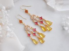 Make a statement this summer with these colorful earrings created with 14k gold filled earrings for a comfortable all day wear! Suspended from the statement earrings are yellow teardrops accented with princess cut magenta pink faceted glass and tiny cubic zirconia charms in a floral design. Whether searching for chandelier earrings earrings for a whimsical wedding or a unique birthday gift for a best friend, all of my jewelry arrives suitably gift wrapped ready for gift giving. Measurements: The Yellow Dangle Chandelier Earrings For Wedding, Yellow Teardrop Earrings For Wedding, Elegant Yellow Chandelier Earrings As Gift, Yellow Dangle Chandelier Earrings For Party, Elegant Multicolor Chandelier Earrings For Celebration, Elegant Multicolor Drop Bridal Earrings, Yellow Drop Earrings For Celebration, Multicolor Chandelier Drop Earrings For Wedding, Yellow Dangle Earrings For Wedding