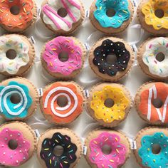 a box filled with lots of different flavored donuts on top of each other