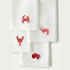 four red lobsters on white napkins with red thread embroidered on the front and back