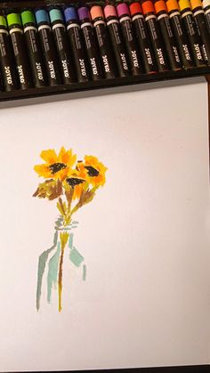 a drawing of sunflowers in a vase with colored crayons next to it